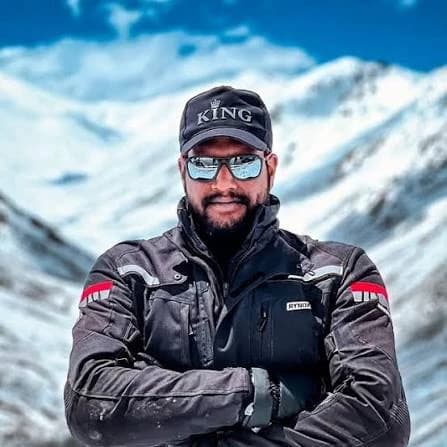 Rider in a riding jacket in front of snow-capped mountains